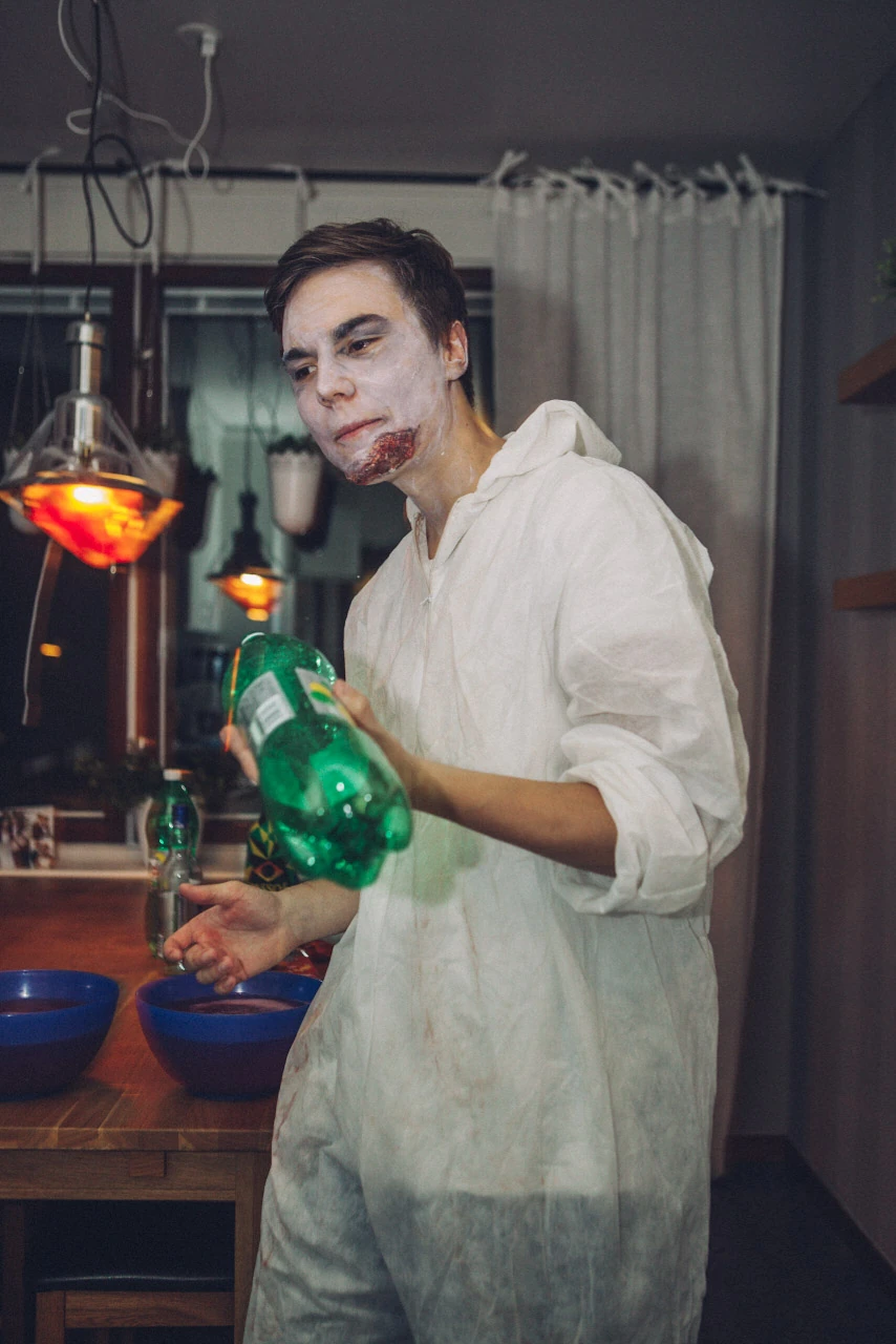 En person med vitt ansiktssmink och ljusa kläder på en maskerad.