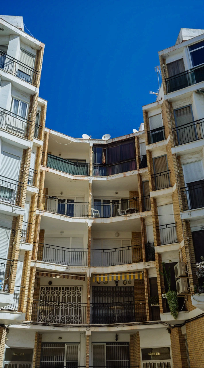 Balconies and pale façades curving around a courtyard.