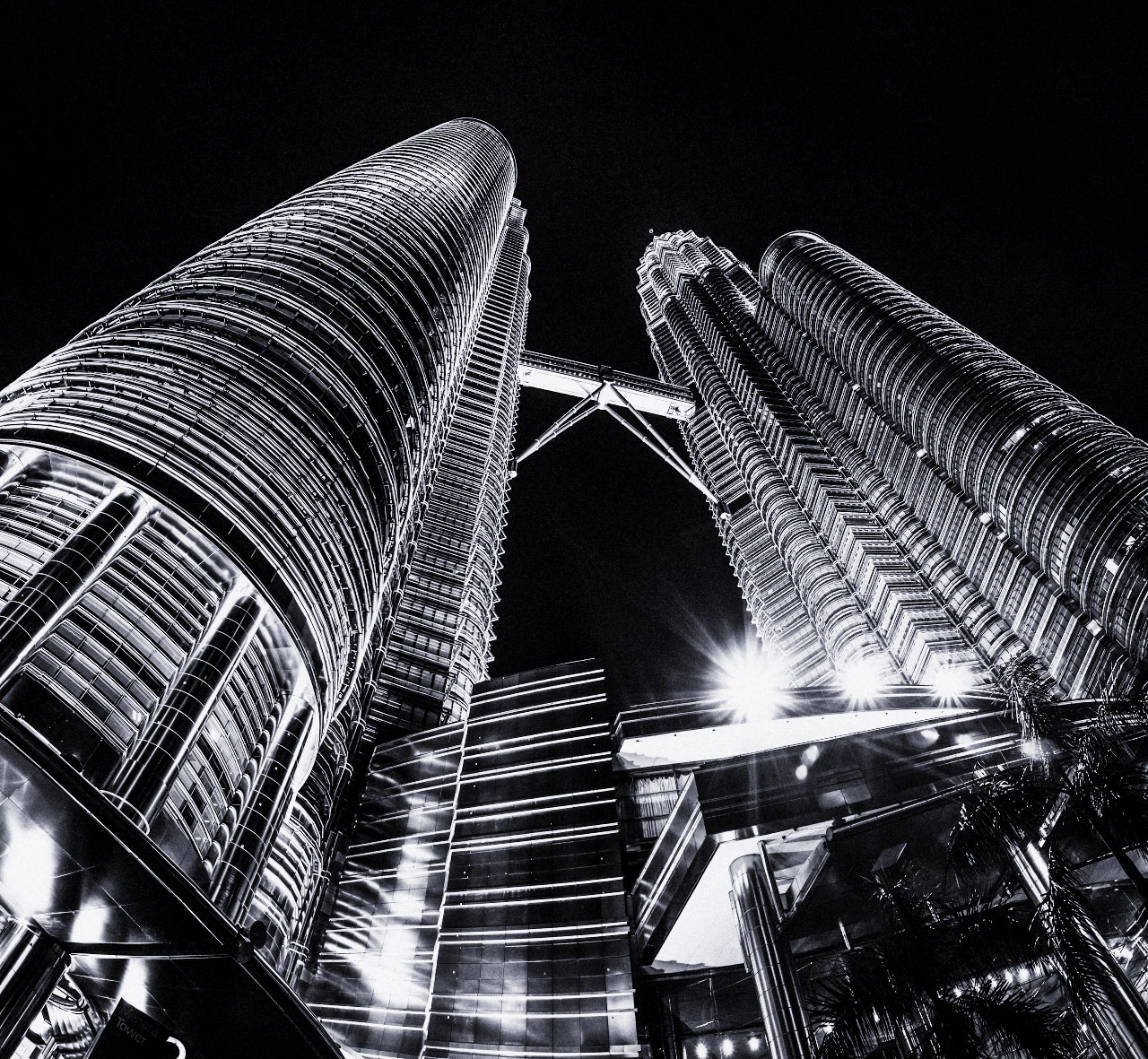 Two tall towers photographed from below against a black night sky in black and white.
