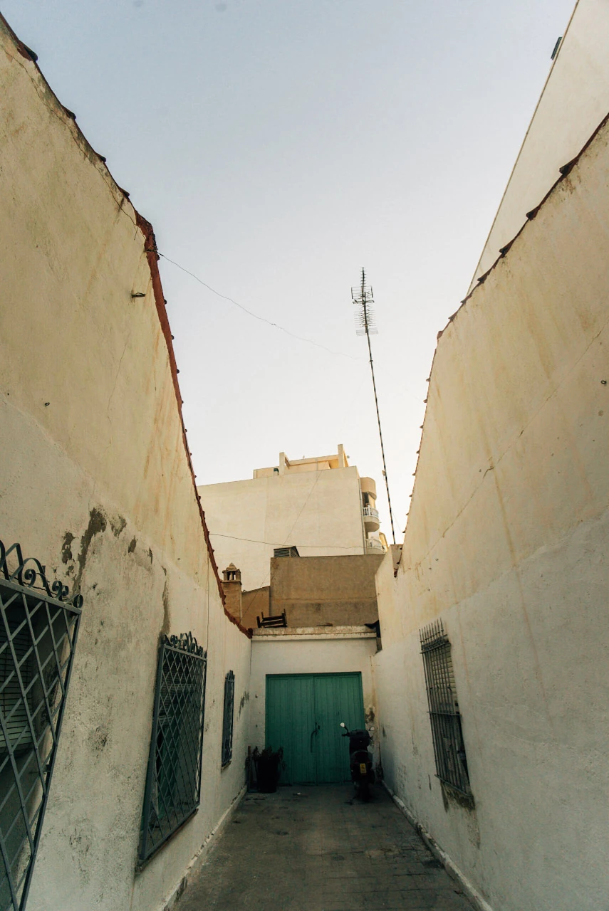 A narrow passage between tall pale walls.